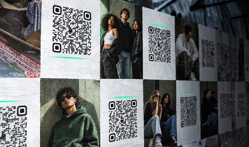 Un muro di manifesti in strada: ogni poster porta il suo codice inquadra.me